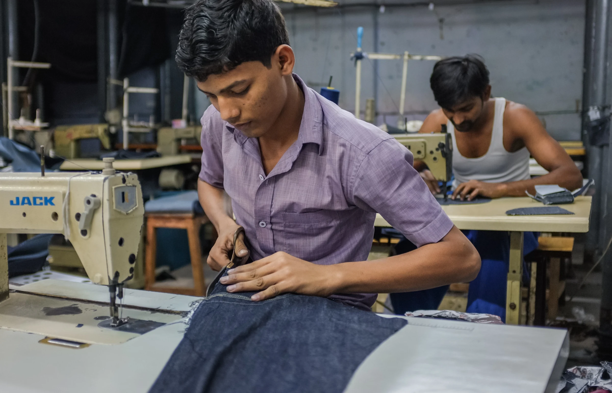 A worker at a sewing machine in a garment workshop